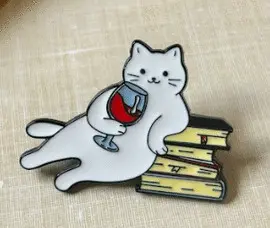 3. GATO BLANCO TOMANDO VINO SOBRE LIBROS - PINES DAZZLE
